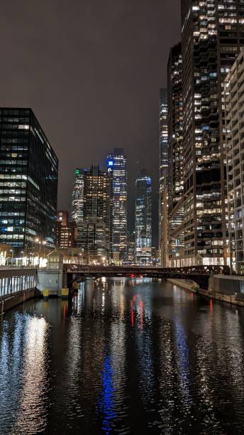 istock Vertical shot of city lights reflecting on a river during nighttime 1459934309