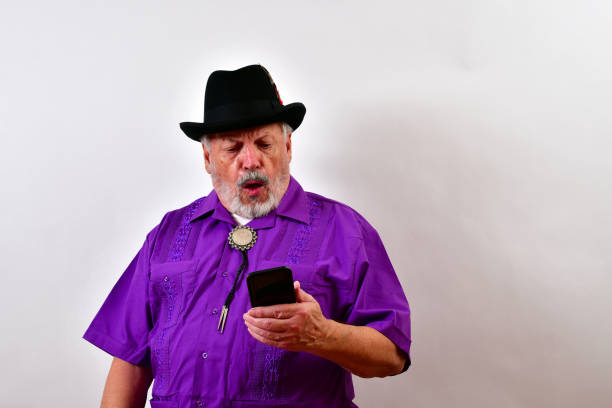 la vista de un caballero anciano se sorprende por lo que ve en su teléfono inteligente. - sombrero homburg fotografías e imágenes de stock