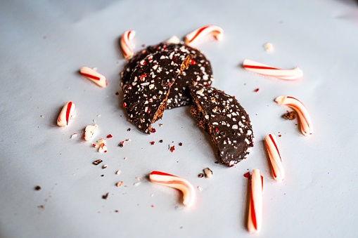 A closeup shot of two halves of a chocolate Christmas candy cane peppermint cookie