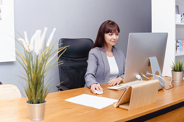 istock A brunette woman at a computer in the workplace. Business concept. 1459937536