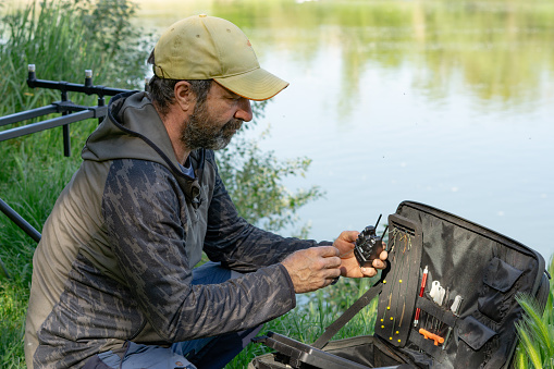 A closeup shot of a Caucasian male with beard carp fishing in the river