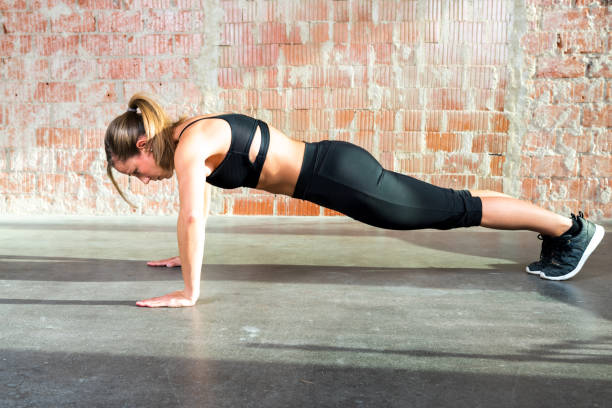 istock Strained young woman exercising doing push-ups in sunlight 1459938229
