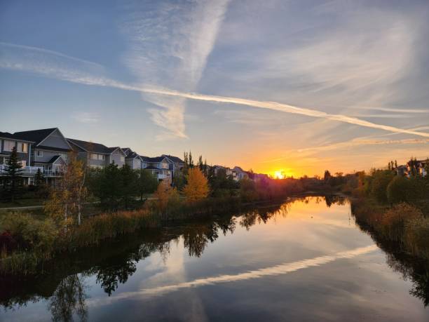 istock Aerial view of river surrounded by buildings and dense trees during sunset 1459938326