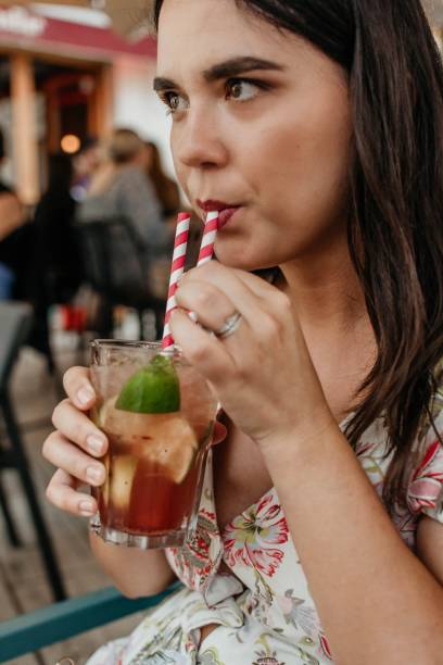istock Young woman drinking fresh cocktail with lime and lemon 1459940272