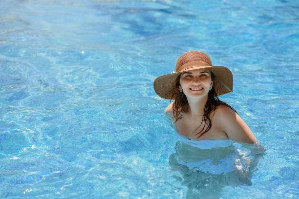 istock woman with a hat in the swimming pool. 1459941628