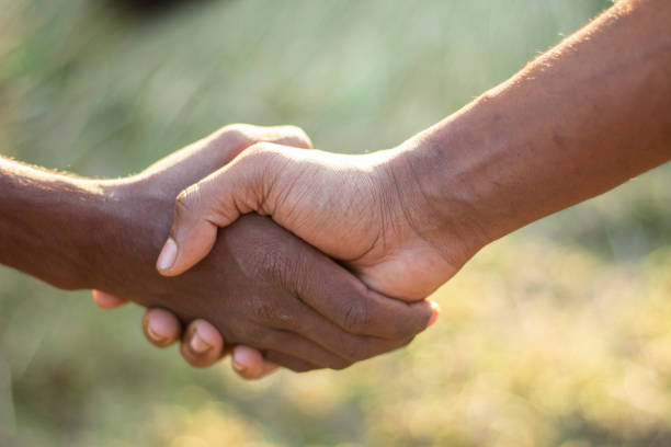 istock Two hands meet with one another hand and the background blurred 1459943318