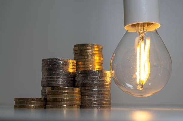 istock Light bulb and coins next to it. Energy costs. 1459945905