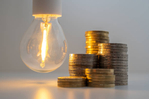 istock Light bulb and coins next to it. Energy costs. 1459946220