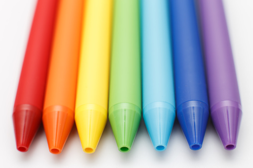 Multicolored in rainbow colors gel pens isolated on a white background, close-up. Copy space.