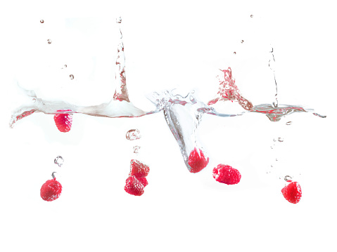 Raspberry falls deeply under water with a big splash. High quality photo