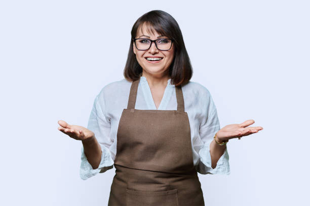 istock Confident middle aged woman in apron looking at camera on white background 1459951973