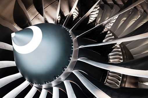 View of the wing and engine of a passenger aircraft and a landing airplane flying in the sky