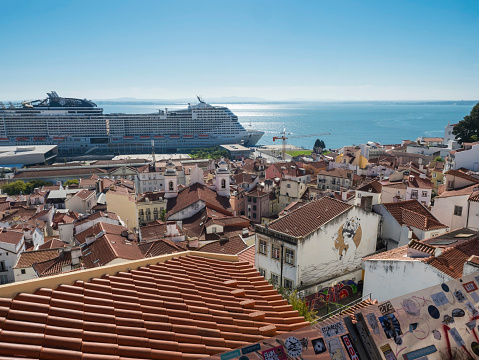 Lisbon, Portugal, October 24, 2021: Aerial view of Lisbon skyline, rooftops and tejo river in Portugal seen from the viewpoint called Miradouro das Portas do Sol at Alfama old town district.