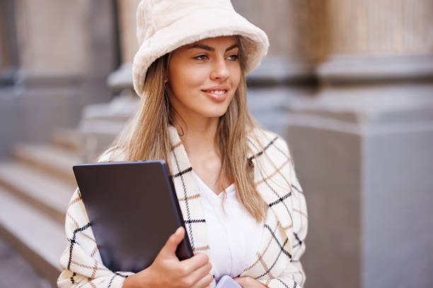 istock Smiling female carrying laptop while leaving college building 1459955909