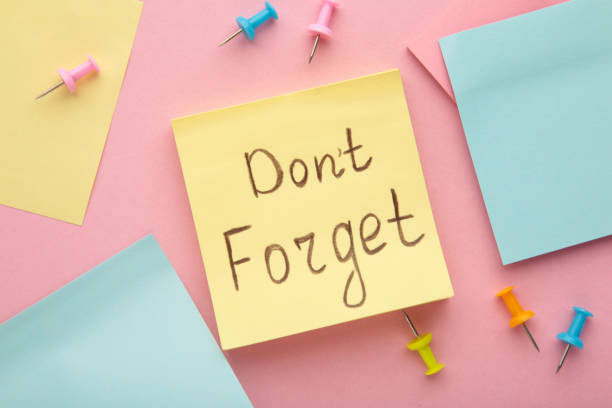 istock Reminder with text 'Don't forget' on a yellow memo on pink background 1459956058
