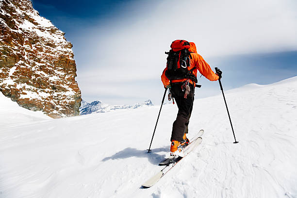 Cross country skiier with orange parka stock photo