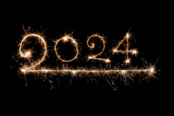 istock Happy New Year 2024. Burning sparkling text 2024 isolated on black background. Beautiful glowing design element for greeting card and holiday flyer. Text 2024 written with sparklers for holiday design 1459959863