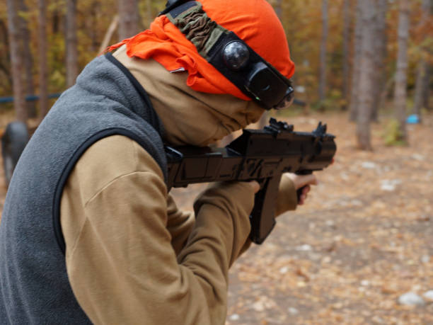 istock a teenager aiming aim at a laser gun while playing in the forest, rear view 1459959947