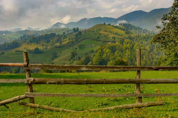 istock Rural idyllic landscape with grassy fields and rolling hills, sunny afternoon, dramatic sun rays piercing the fluffy clouds. Wonderful springtime landscape in mountains. Nature freshness concept 1459960615
