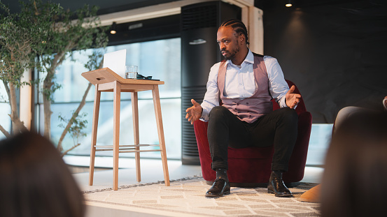 A businessman is talking to a group of business people.