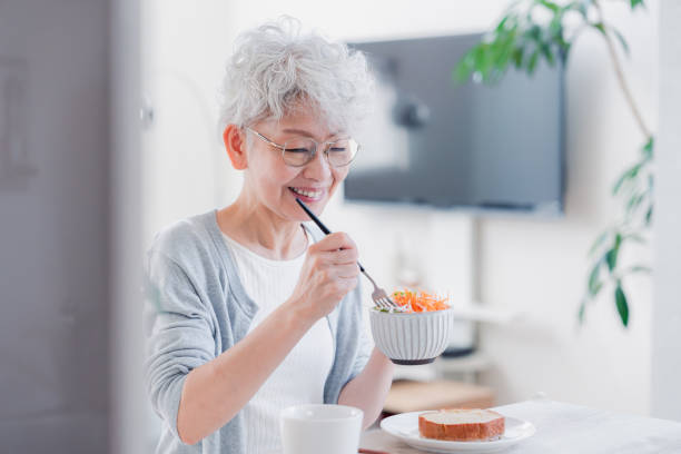 istock Senior woman eating breakfast with a smile 1459962295