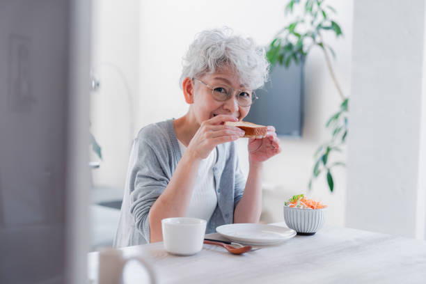 istock Senior woman eating breakfast with a smile 1459962372