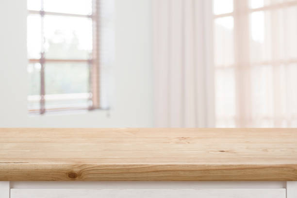 istock Wooden table top with blurred windows background for product display 1459963902