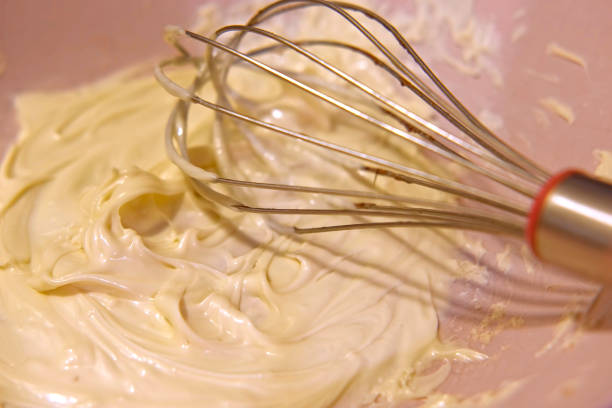 istock Preparing whipped liquid white chocolate. melted chocolate in a mixing bowl. Top view. Closeup of molten hot chocolate swirl. Confectionery. Pouring premium milk chocolate. Prepare dessert, icing 1459965709