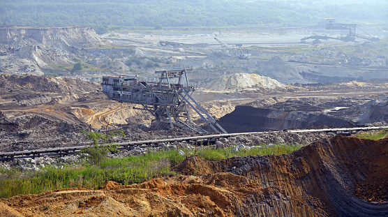 Bucket-wheel excavator during excavation at the surface mine. Huge excavator on open pit mine.