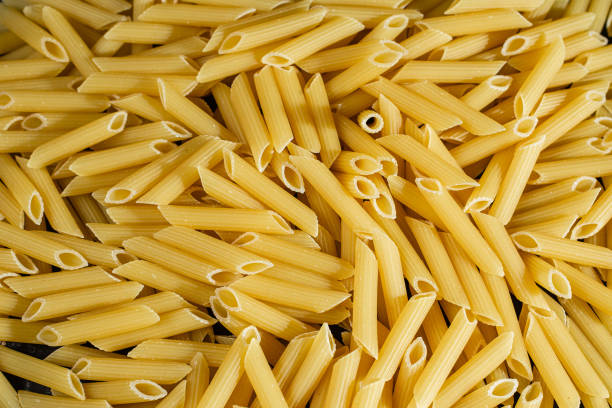 primer plano de pasta cruda. fondo de pasta - penne fotografías e imágenes de stock