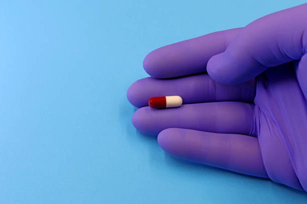 istock Doctor's hand with a capsule, antibiotic, or medicine pill 1459967399