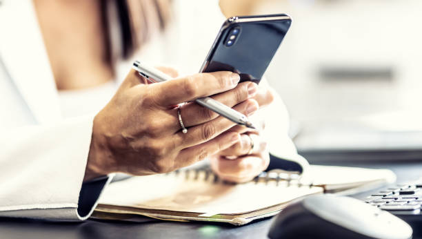 istock Hands of a female manager with a mobile phone, communicating with colleagues during working hours, sending messages or receiving work information. 1459969571