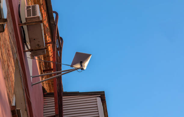 Starlink satellite dish, an internet constellation operated by SpaceX, is installed on the wall of an apartment building. stock photo