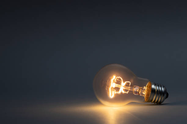 暗闇の中で光る古典的な電球 - tungsten ストックフォトと画像