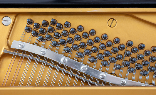 Details of piano mechanism gavel - string, pins and hammers, piano from 1973