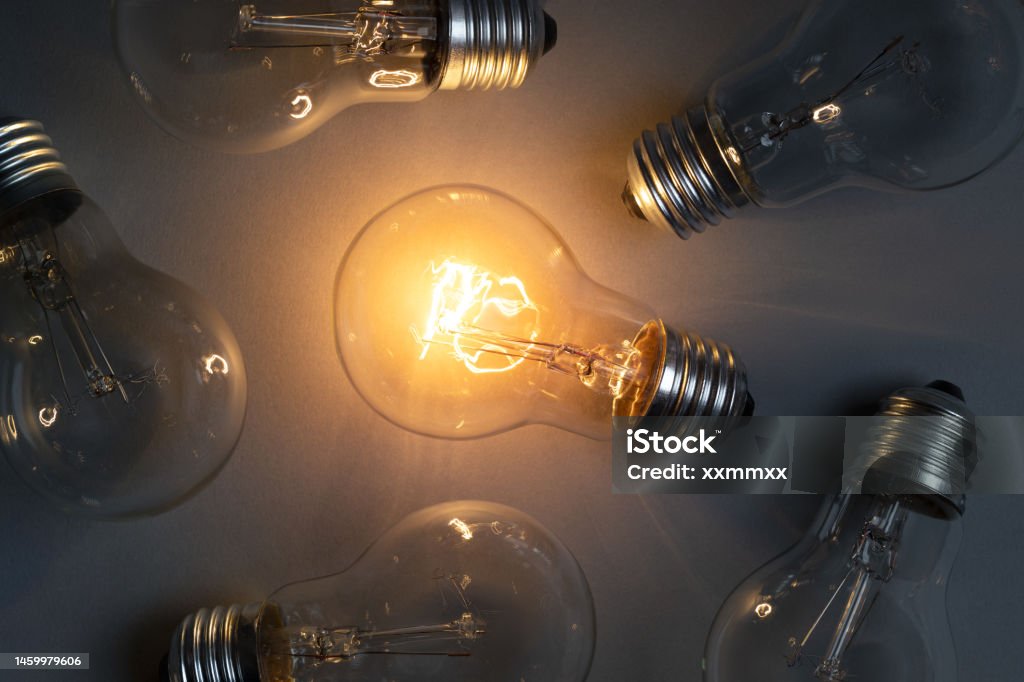 Idea concept with classic light bulb glowing Idea concept with classic light bulb glowing in the dark. This file is cleaned and retouched. Discovery Stock Photo