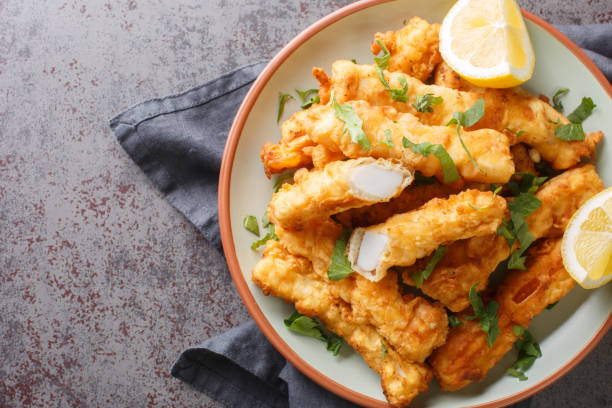 istock Deep Fried Breaded calamari strips with lemon closeup on the plate. Horizontal top view 1459985603