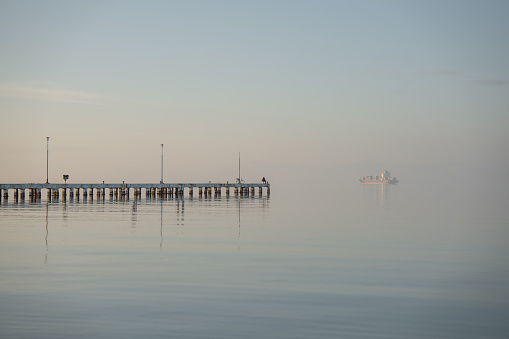Pier in distance on a calm blue sea