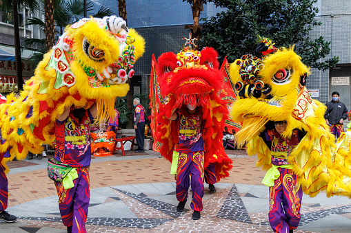 Hong Kong - January 27, 2023 : A lion dance team performs at Sheung Wan to celebrate the Chinese New Year in Hong Kong.