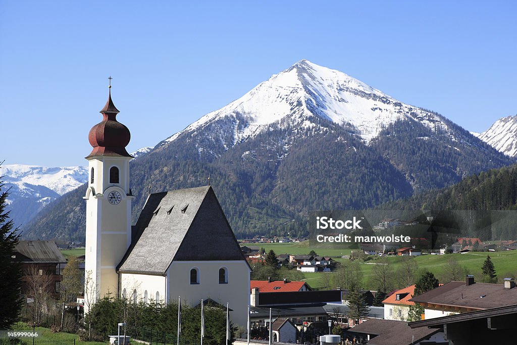 traditional austrian church in Tirol with snowcovered mountain Austria Stock Photo