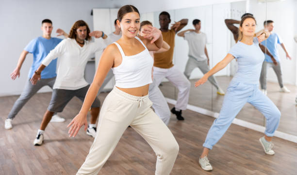 Group of different people rehearsing dance in dance studio stock photo