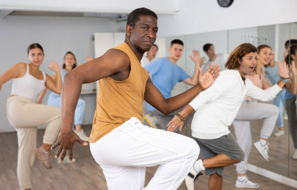 istock African american man practicing active  dance moves during rehearsal with group in dancing studio. 1459990895
