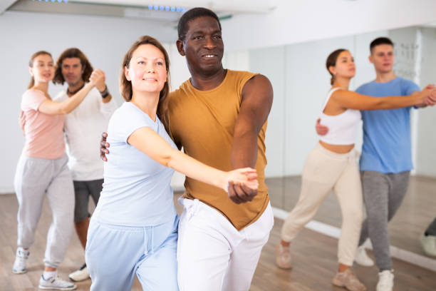 istock Woman and man practicing modern dance moves in pair during group class 1459991048