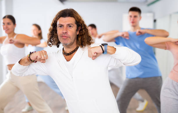 istock Group of smiling people of different ages dancing and practicing new movements in class. Sport, dance and urban culture concept 1459991050