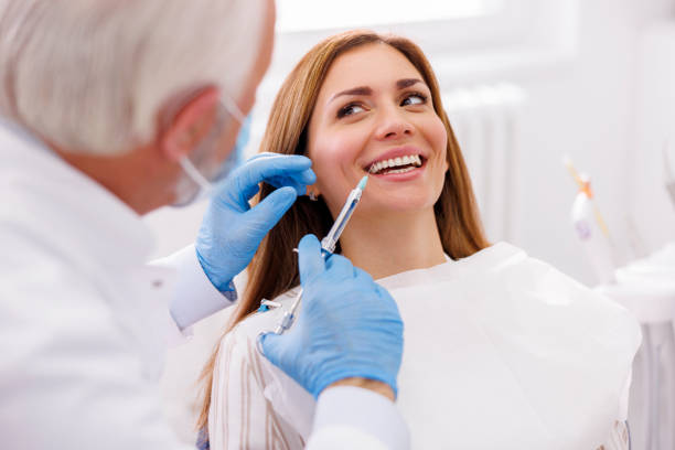 istock Dentist applying local anesthetic to female patient 1459991817