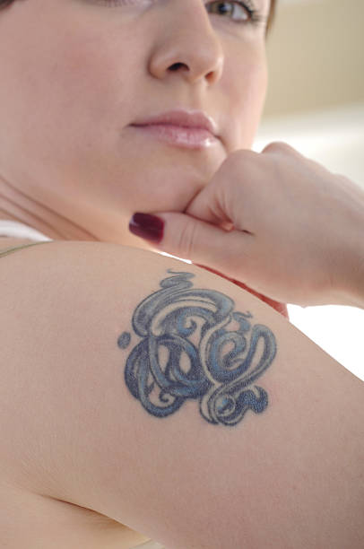 Tatoo on woman's shoulder stock photo