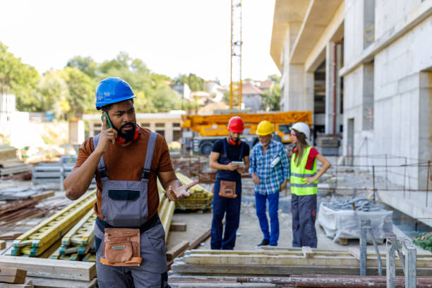 istock An African Construction Engineer is Talking with Coworkers Using a Phone. 1459995255