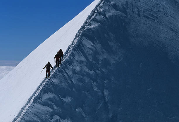 POV climber holding a rope for his partner, young woman to safely descend down the Via Ferrata in Swiss Alps.