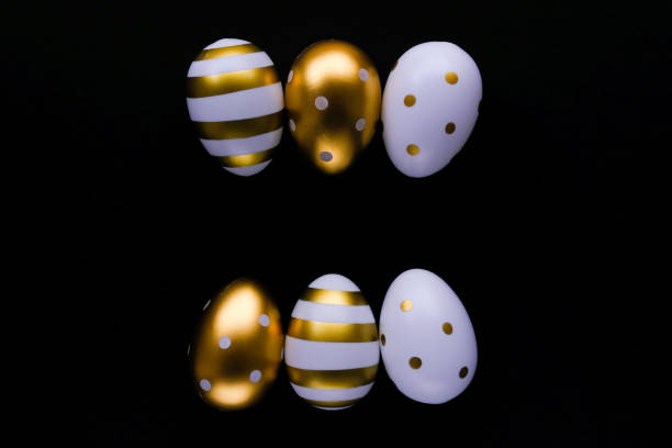 istock Gold Easter eggs in a row on a black background. Festive Easter concept. Flat style, space for text. 1460001000