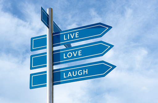 Live Love Laugh message on signpost isolated on blue sky background